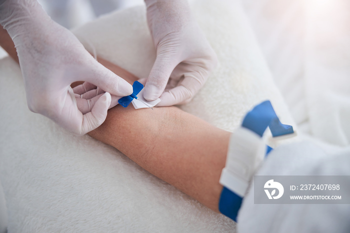 Certified doctor preparing a patient for the intravenous therapy