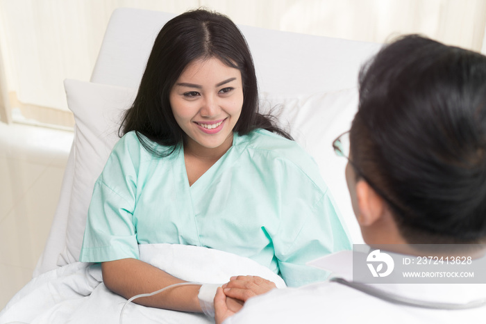 Doctor encouraging patient during treatment therapy and holding hands to support.