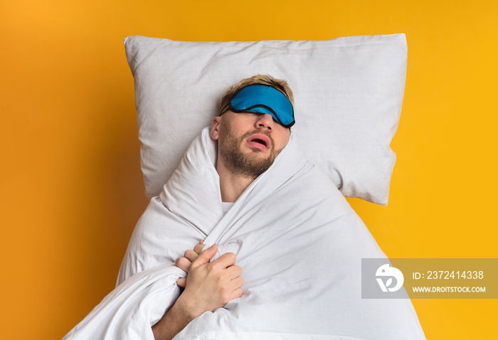在舒适的床上睡个好觉。男人戴着口罩睡觉