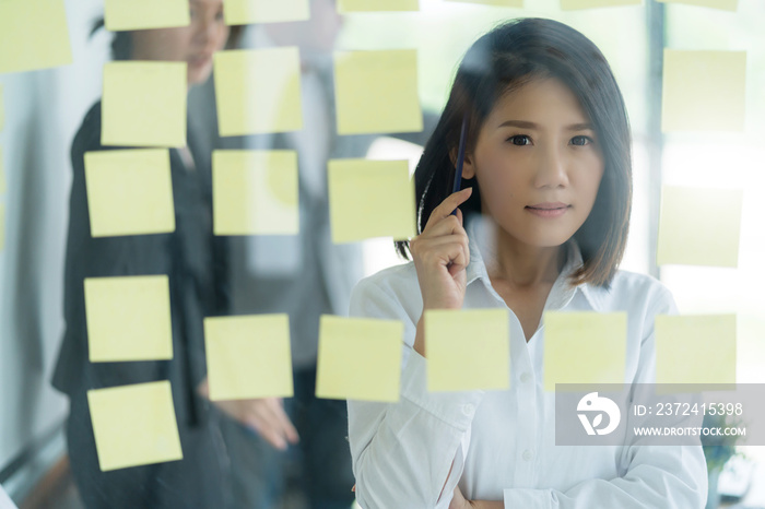 聪明而有策略的亚洲经理女性思维和在白人办公室工作的背景商业理念