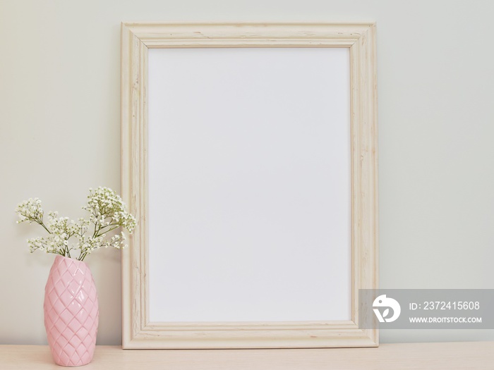 Empty decorative frame mockup, pink vase with flowers, styled feminine photography.