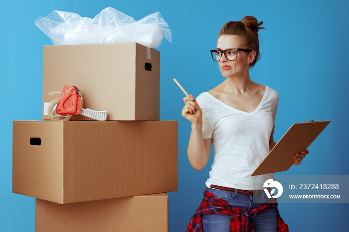 woman near cardboard box using moving checklist and count boxes