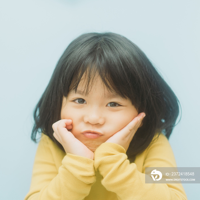 Portrait of young cute little asian girl in winter.4 years old little girl with yellow shirt and loo