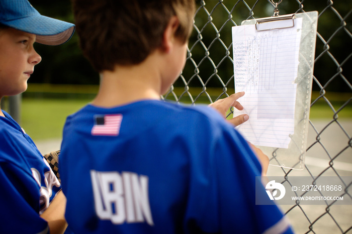 Baseball players looking at lineup list