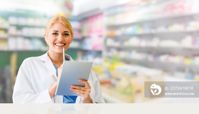 Pharmacist using tablet computer at the pharmacy. Medical healthcare and pharmaceutical staff servic