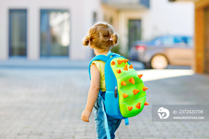 可爱的蹒跚学步的小女孩第一天去幼儿园。健康美丽的婴儿对讲机