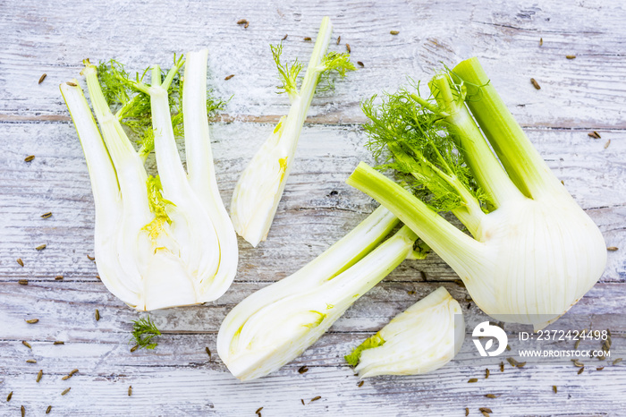 Fresh and raw fennel bulbs on wooden background.