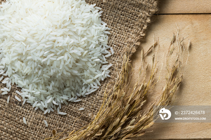 Jasmine rice in sack on wood table,top view