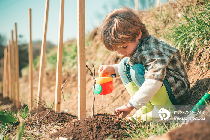 Little farmer with Shovel and watering can. Little helper in garden Planting flowers. Child Farmer p