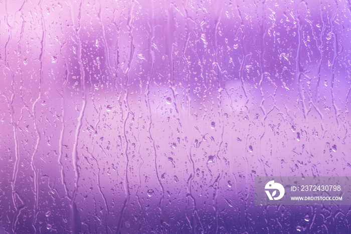 Rain on a window in purple colors