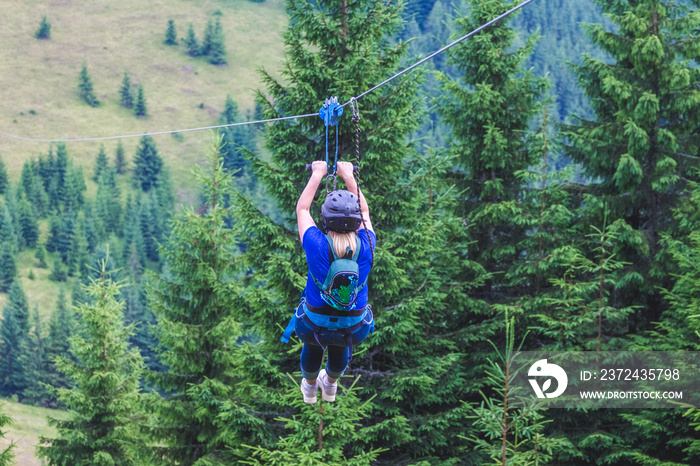 乘坐金属电缆从山上下来。Zipline在大自然中是一种极端的乐趣_