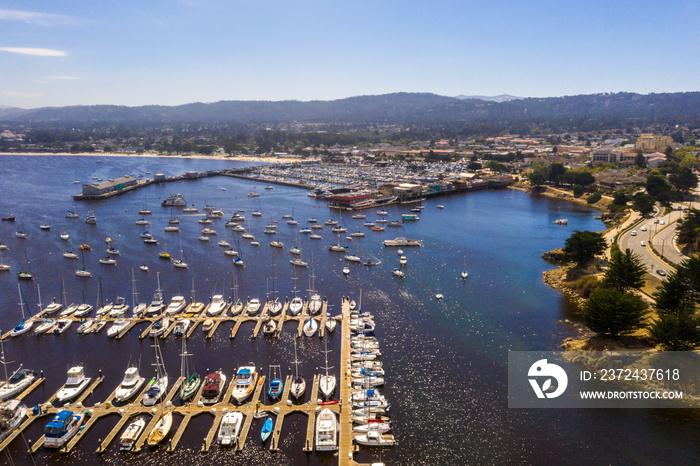 Aerial view of the Monterey Bay Aquarium, Pacific Grove with many yachts docked by the coastline in 