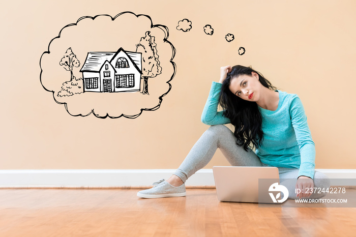 Dreaming of new home with young woman using a laptop computer