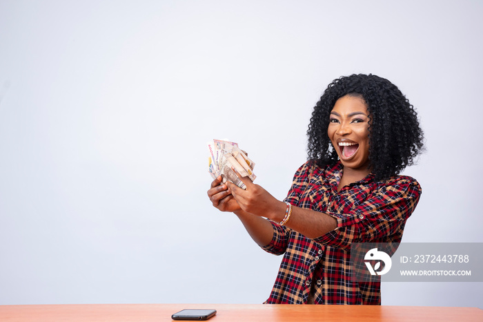 beautiful african lady holding some cash feeling excited and happy