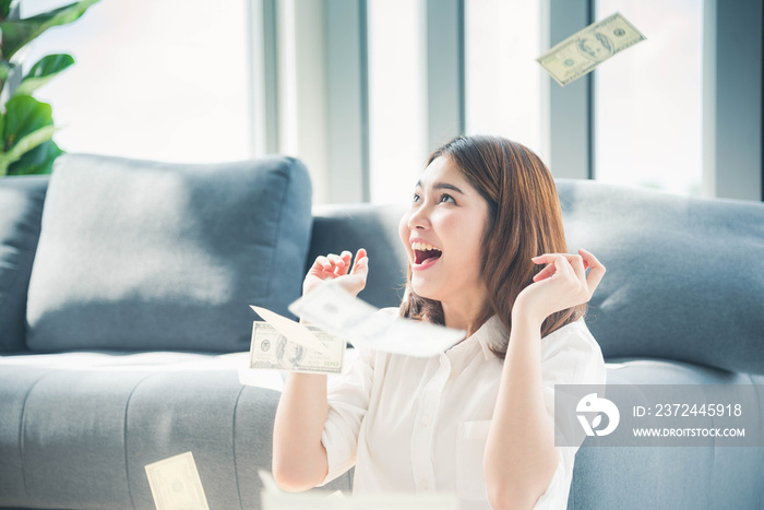 Happy young asian woman holding dollar money and throw in the air celebrate happiness dance wealth l