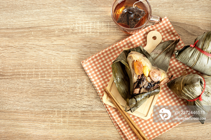 Close up Zongzi or rice dumpling on the wooden table with Chinese tea in Dragon Boat Festival, Asian