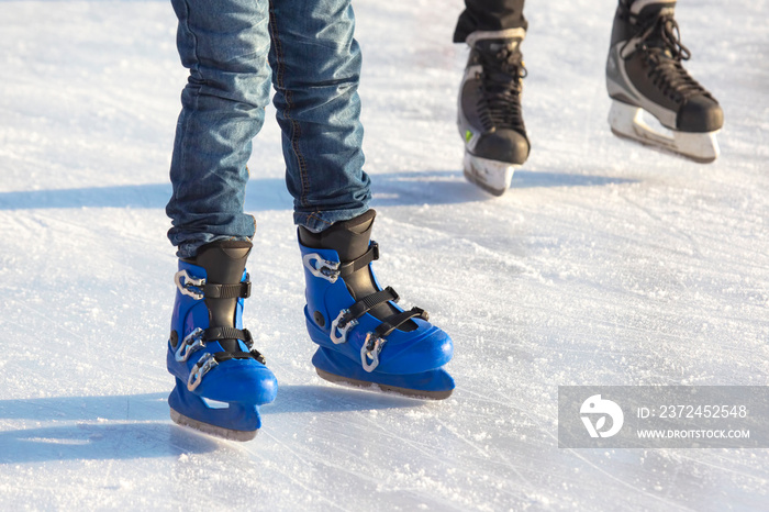 different people are actively skating on an ice rink. hobbies and leisure. winter sports