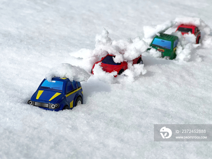 雪の上に並べて置いたミニカー4台_ななめ