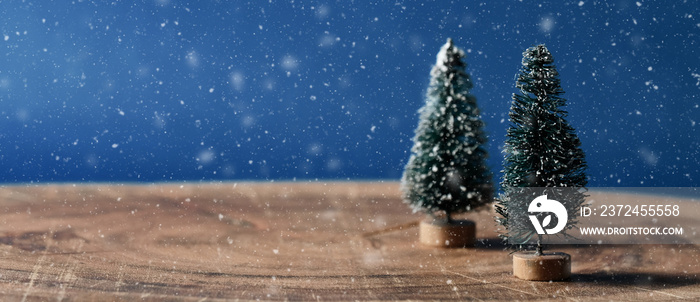 Sisal Christmas trees with snow on wood surface and copy space on blue background for winter holiday