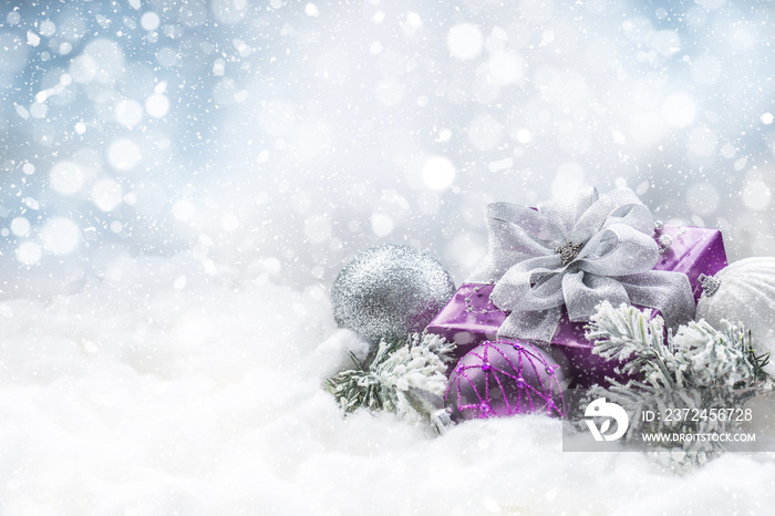 紫色圣诞礼物和雪上的球，上面有冷杉树枝。圣诞快乐的概念