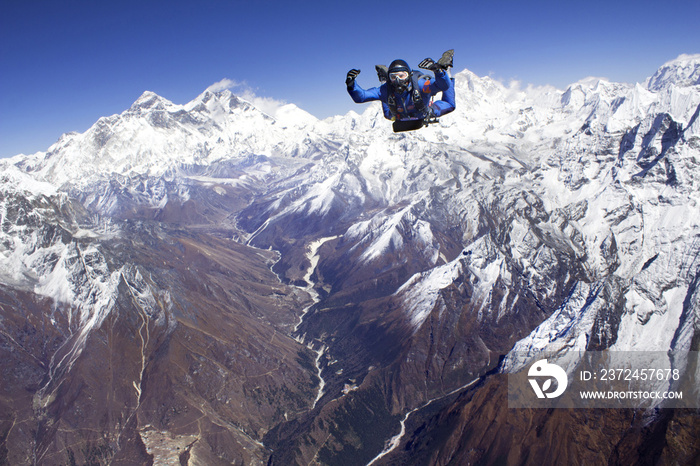 Man skydiving against snowcapped mountains