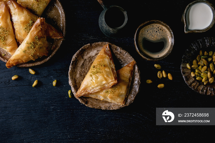 自制土耳其传统甜点baklava配开心果，装在陶瓷盘子里，配一碗坚果