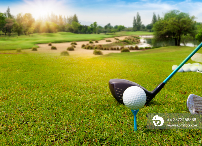 Golf ball on tee ready to be shot in green grass on blurred beautiful landscape of golf course with 