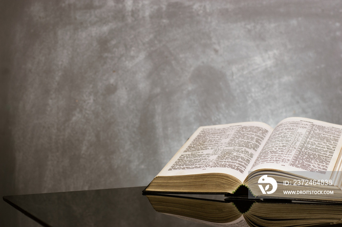 Bible and a crucifix on a black glass table. Beautiful background.Religion concept.