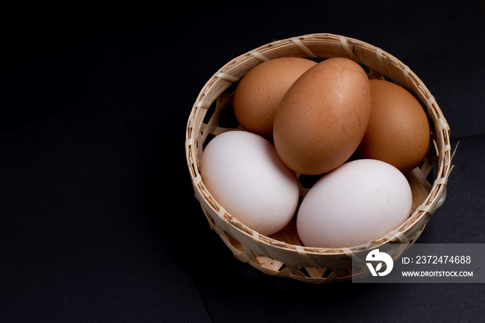篮子里的新鲜鸡蛋，篮子里的鸭蛋和鸡蛋，健康鸡蛋，黑底
