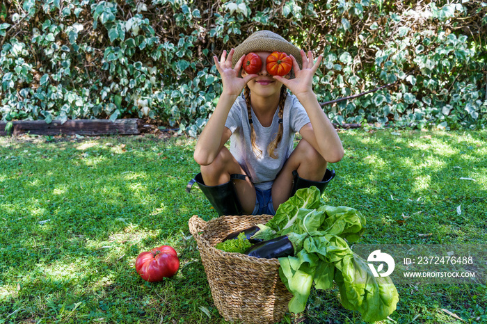 一个高加索小女孩在花园里享用蔬菜。