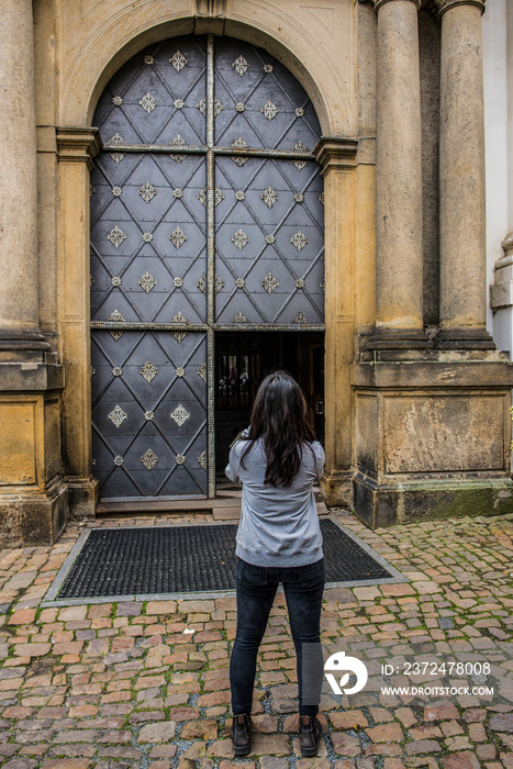 Rear view of woman standing in front of decorative arched doorway, Prague, Czech Republic