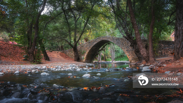 Venetian bridge in Cyprus in the Troodos mountains. Beautiful autumn landscape with river, trees and