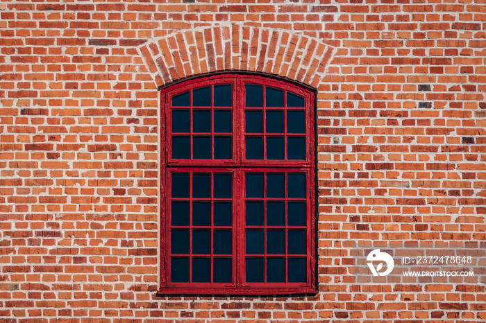 旧建筑的砖墙，带有带横杆的红色大窗户