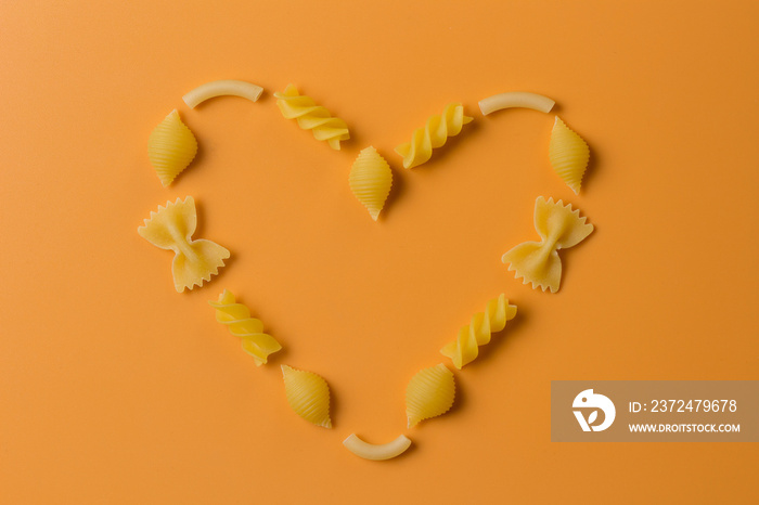 Heart made of pasta on an orange background