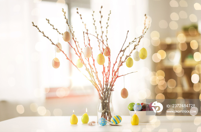 节日和对象概念-用花瓶里的复活节彩蛋和蜡烛装饰的猫咪柳枝