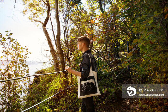 Young man with bag looking at view