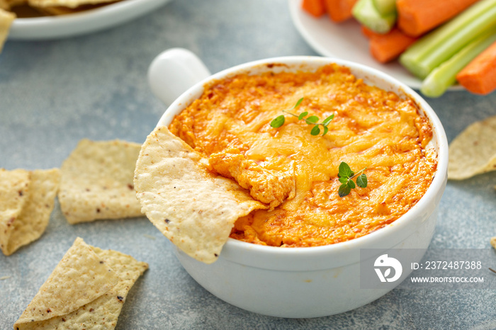 Buffalo chicken dip served with chips and fresh vegetables