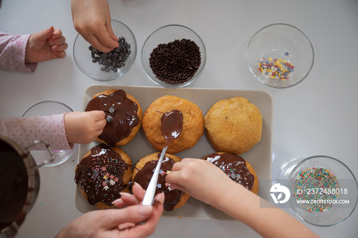 Kids decorating home made doughnuts with sprinkles