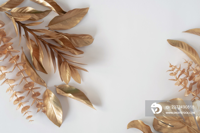 Gold tropical palm leaves Monstera on white background. Flat lay