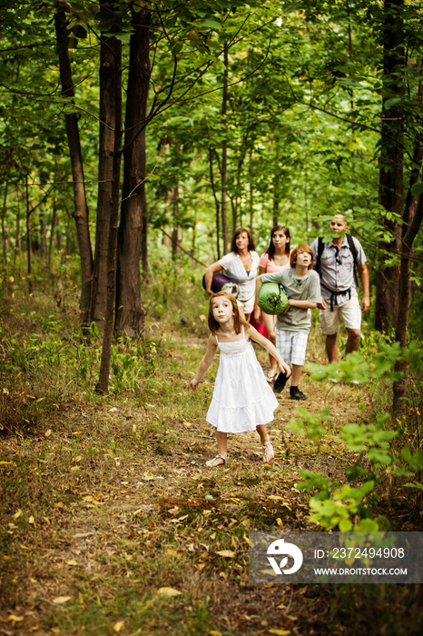 Family with three children walking through forest