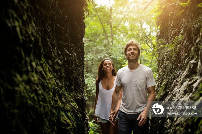 Young couple exploring ravine in forest