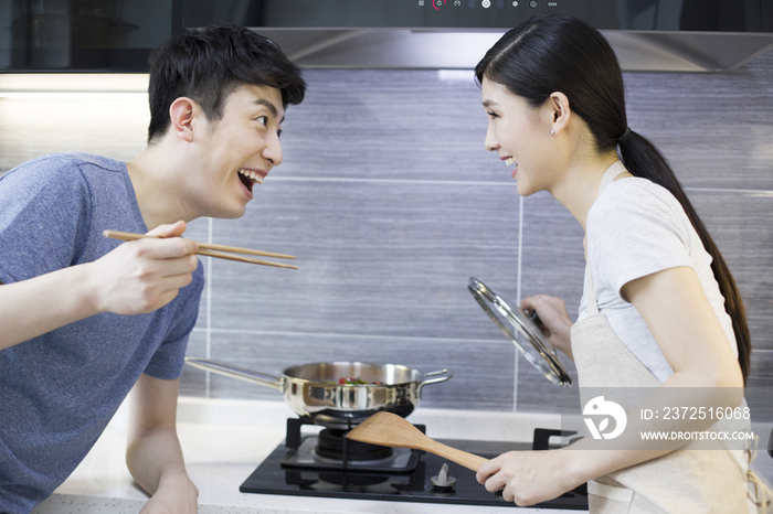 快乐的年轻夫妇在厨房做饭