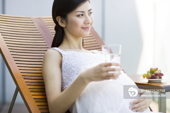 孕妇靠在躺椅上喝水
