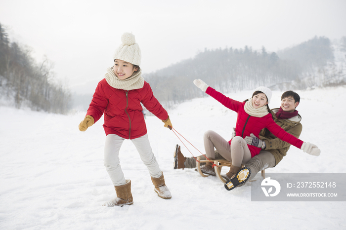 快乐的一家人在雪地上玩雪橇