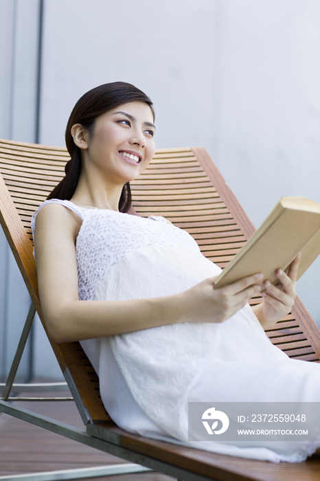 孕妇靠在躺椅上看书