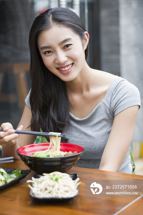 年轻女子吃面条