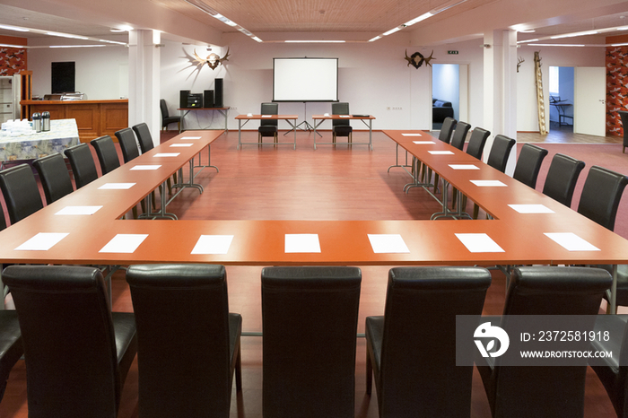 Tables and chairs arranged for a presentation, with a whiteboard