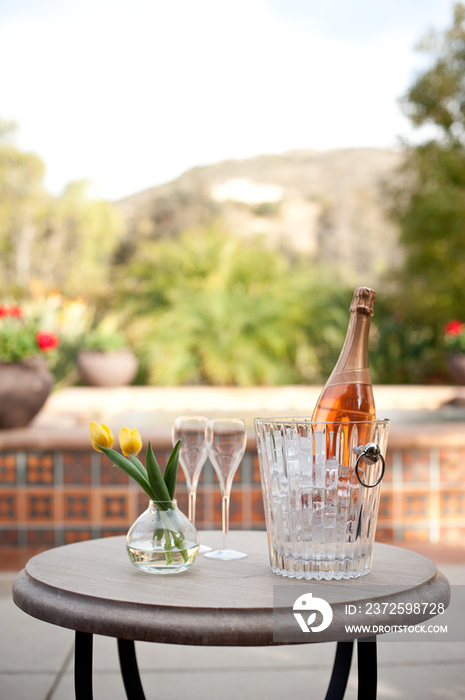 Champagne bottle and flutes on table in resort