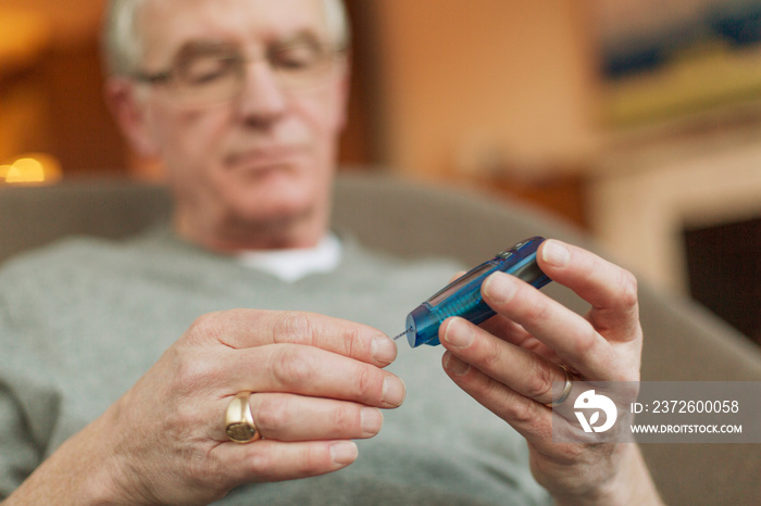 Senior man measuring sugar level with test stick