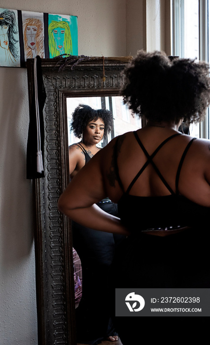 Black woman admiring herself in the mirror